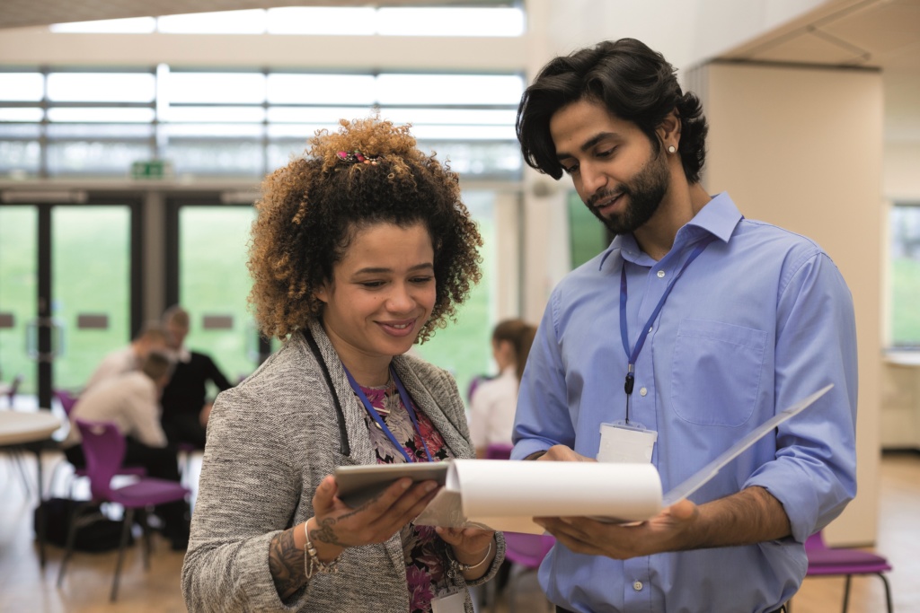 Male and Female professionals looking at clipboard