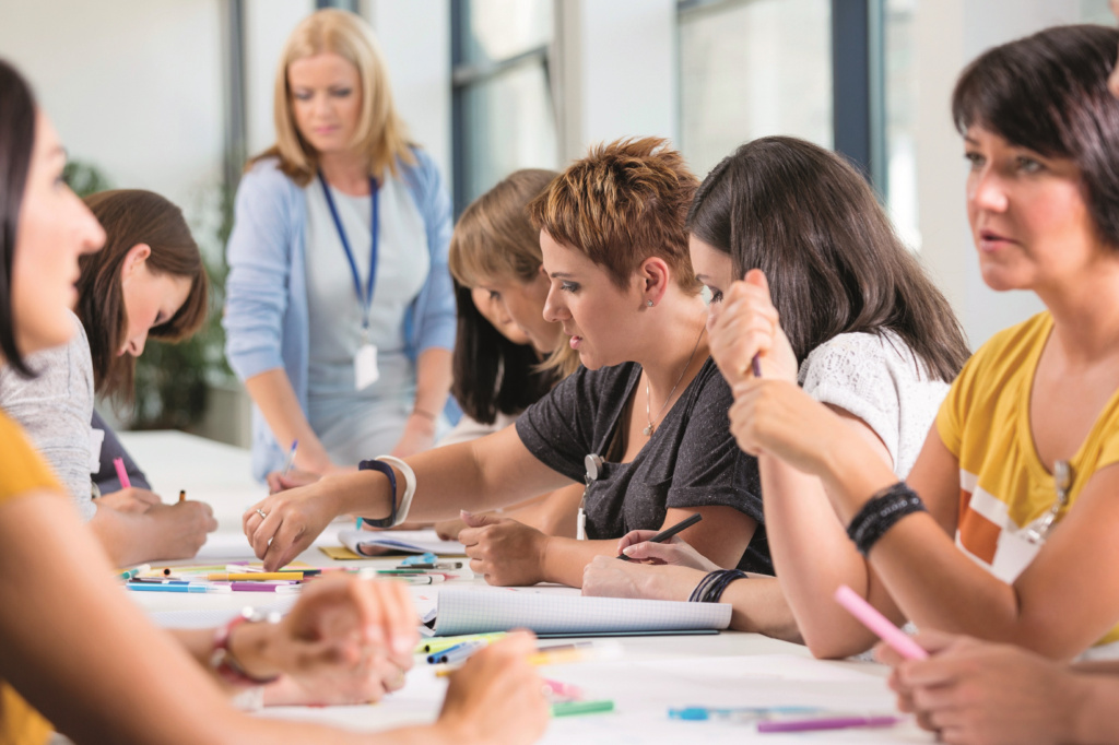 Female teachers doing activity around desk