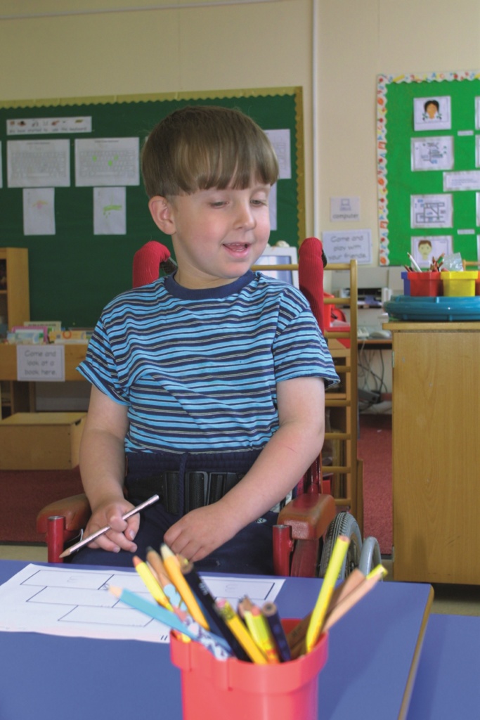 SEN primary boy pupil standing at desk