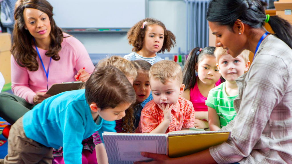 nursery children listening to teacher read a story