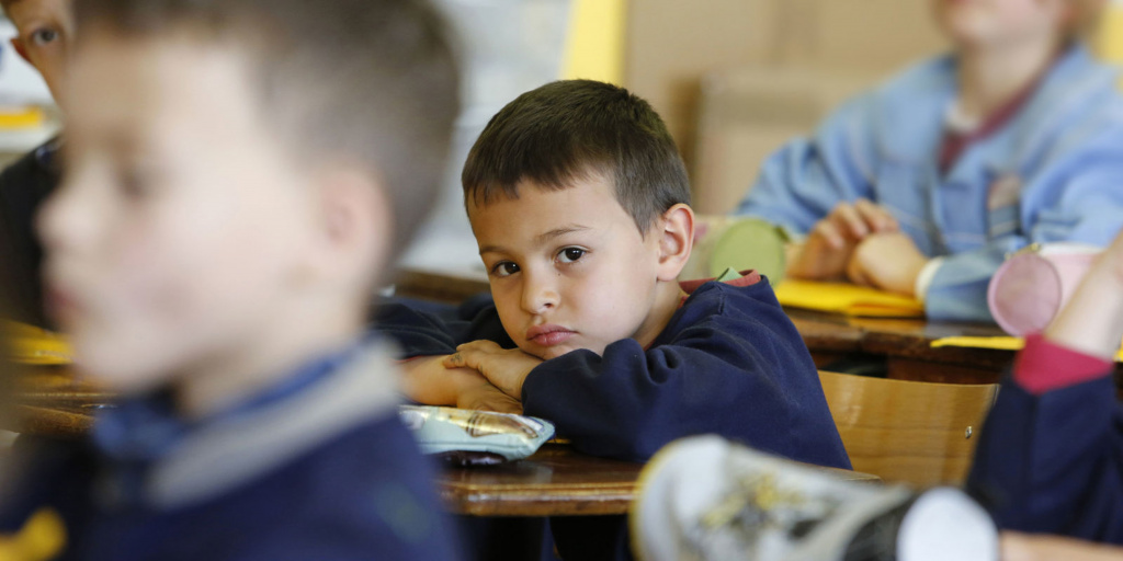 Young boy leaning on his hands at desk