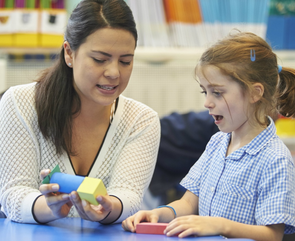 Teacher with primary school girl and blocks