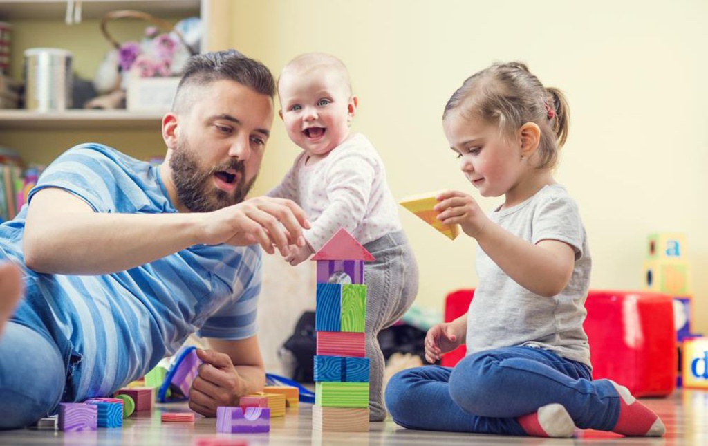 dad with children building blocks