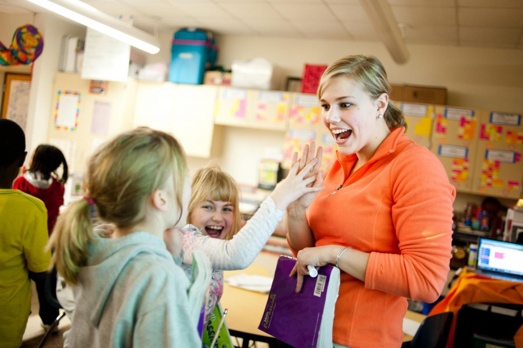 Teacher high-fiving primary pupil 