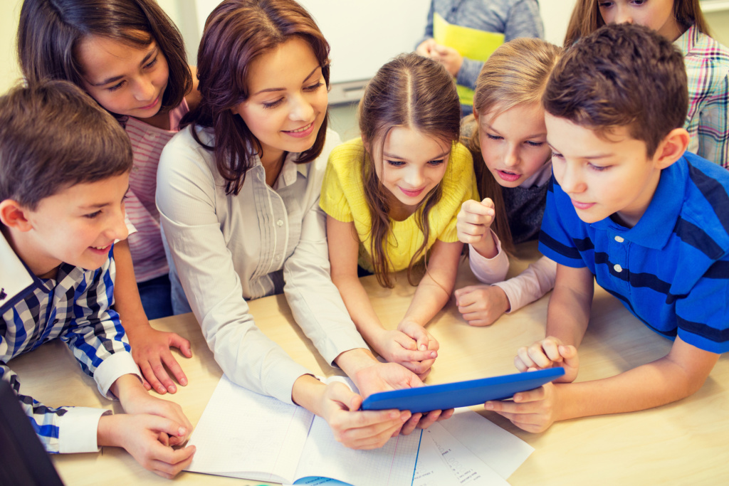 Group of kids with teacher and tablet pc at school