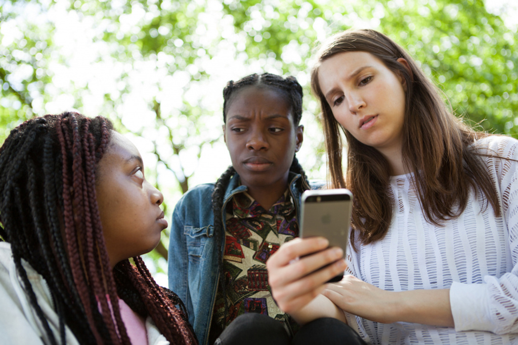 Young people looking at phone in contempt