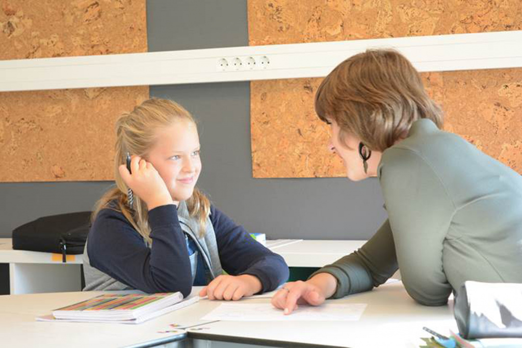 Young girl talking to teacher