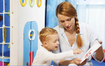 Teacher with nursery child looking at letter card