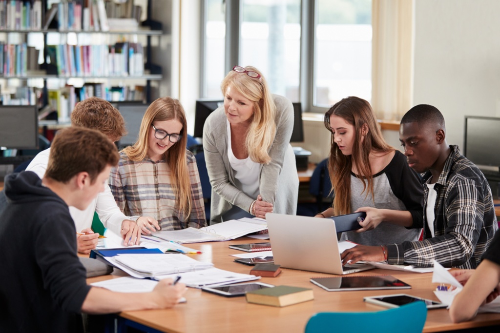 FE Students sitting at desk with teacher standing