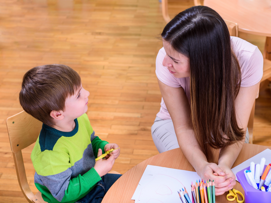 Teacher talking to young pupil