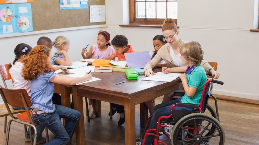 Teacher sitting around a table with pupils