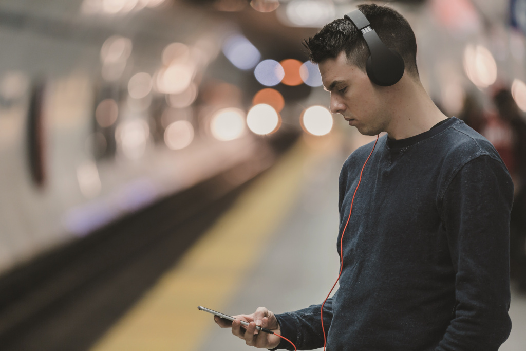 Young man with headphones and iphone in underground