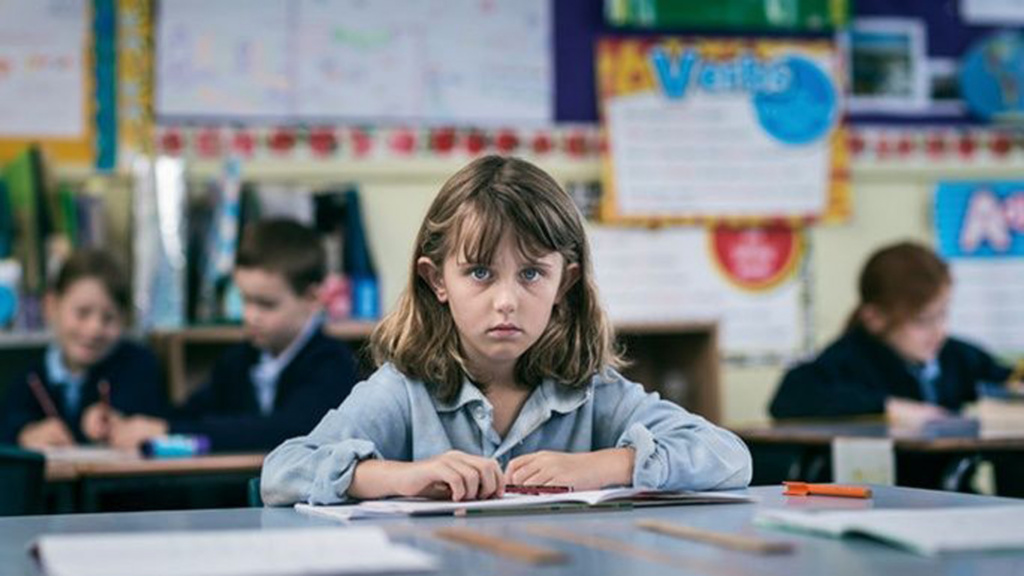 Girl in blue shirt sat at front of class