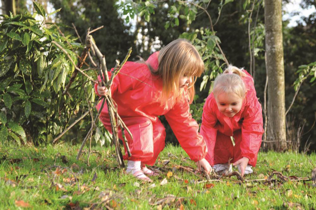 pre-school girls collecting from forest floor