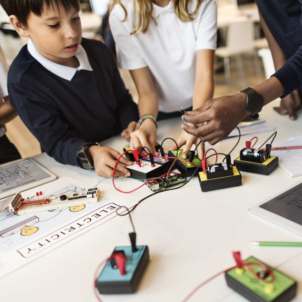 Teacher helping students with technology based task