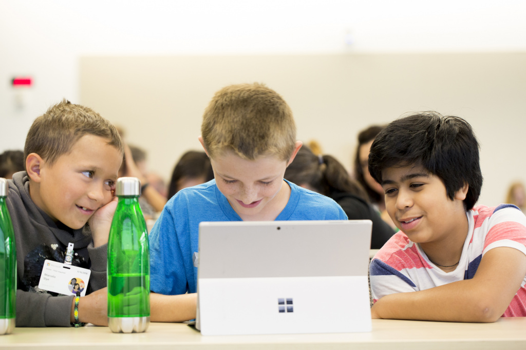 Young pupils using laptop