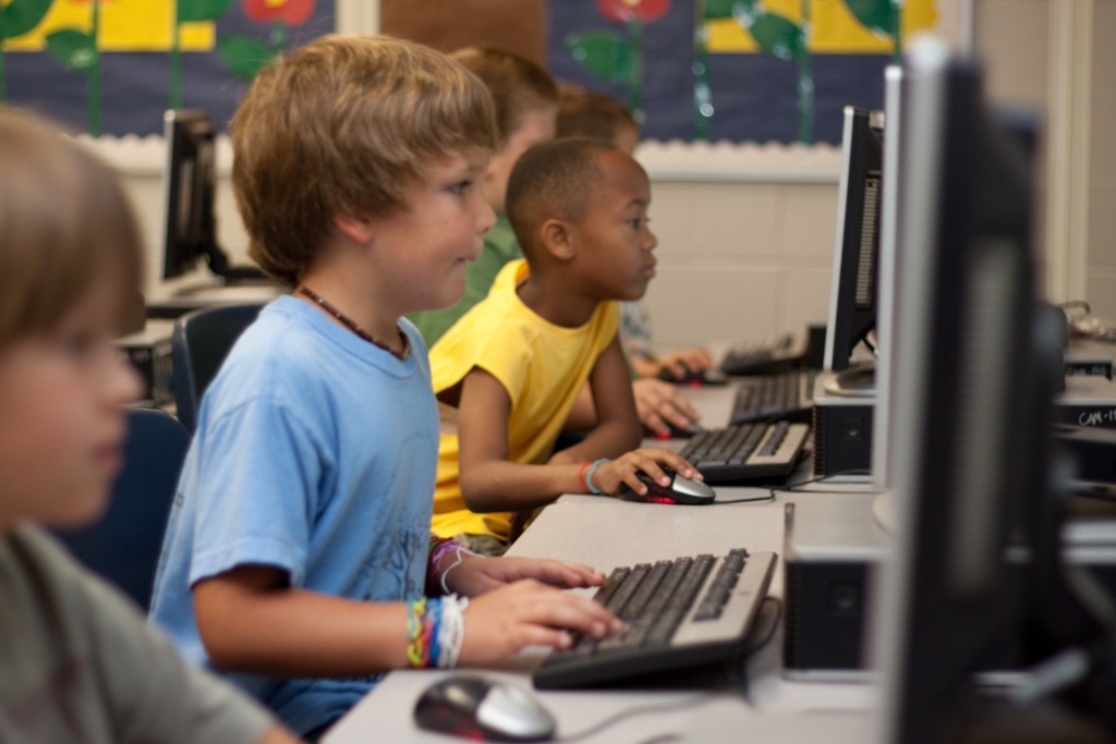 Side profile of children in a classroom using computers