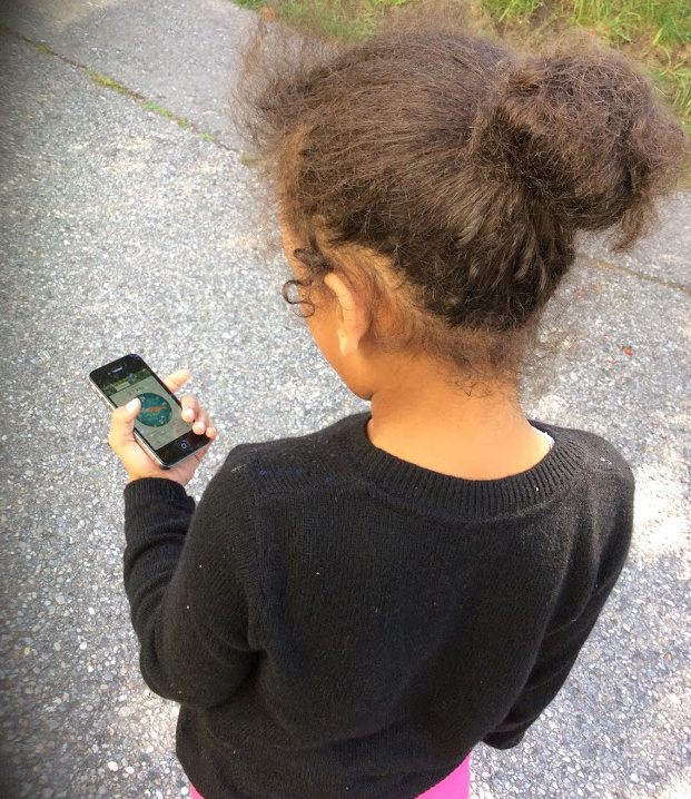 Back view of a girl holding a mobile phone