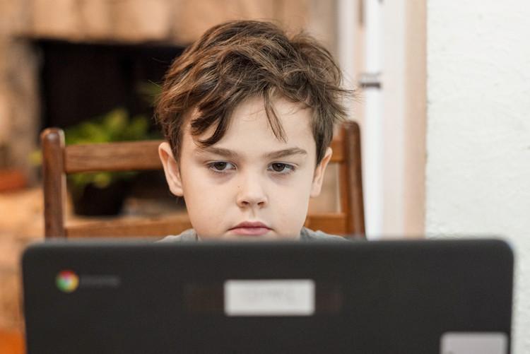 Boy sitting in front of a computer montioor