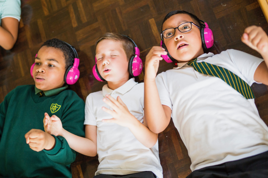 Three children with pink headphones