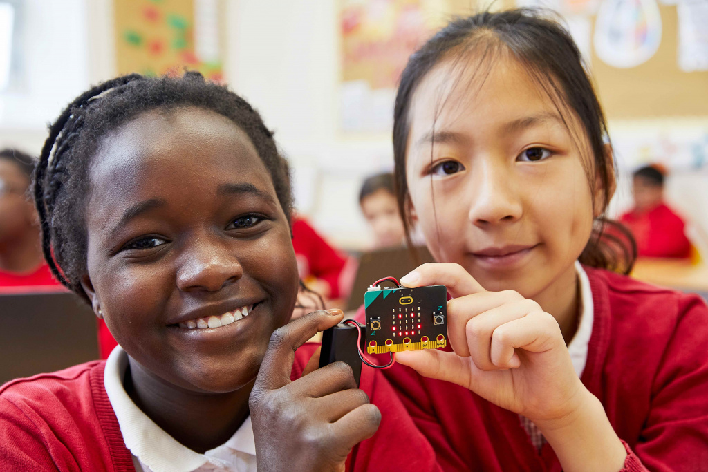 Black and Asian pupils using a micro:bit in a design technology lesson.