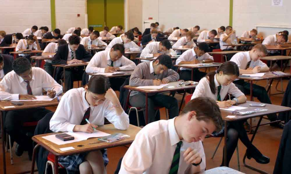 A hall of secondary school students sitting an exam.