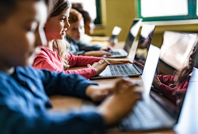 Primary school children using laptops