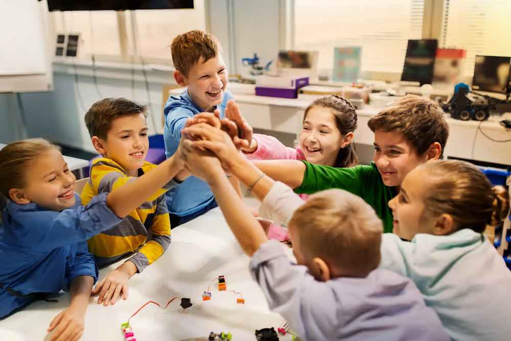 Team of primary school students clasping hands