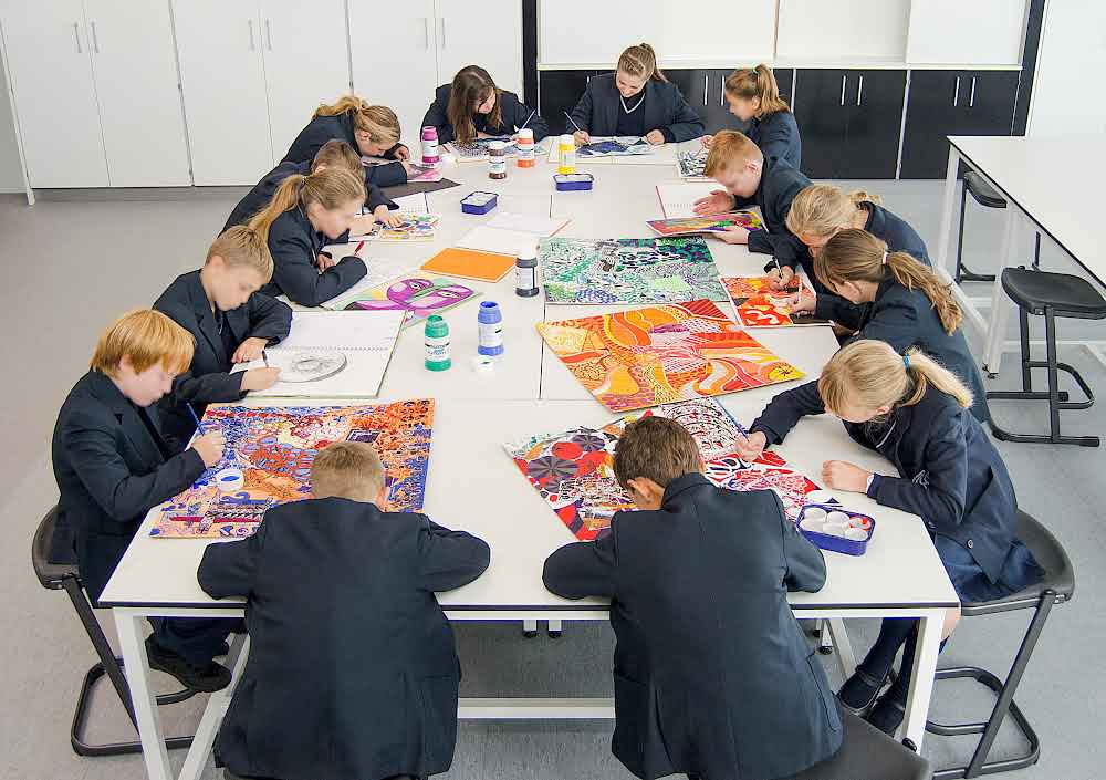 School pupils drawing art at a table
