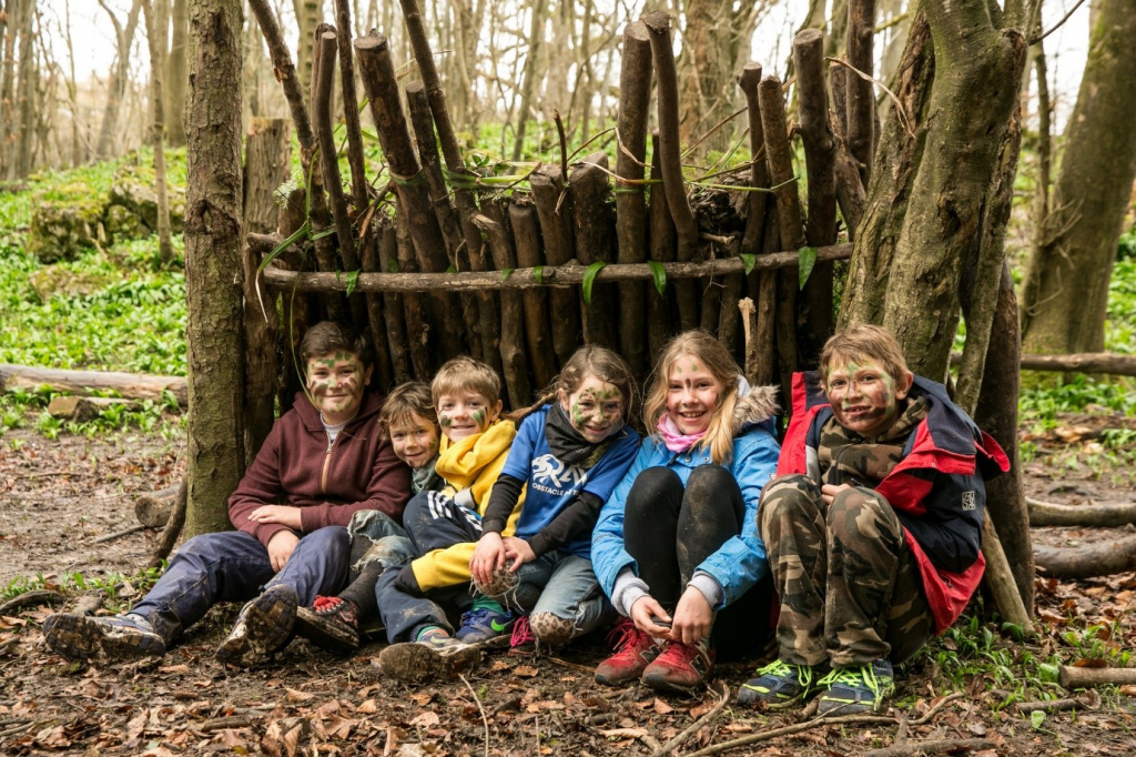 School children in a woodland shelter.