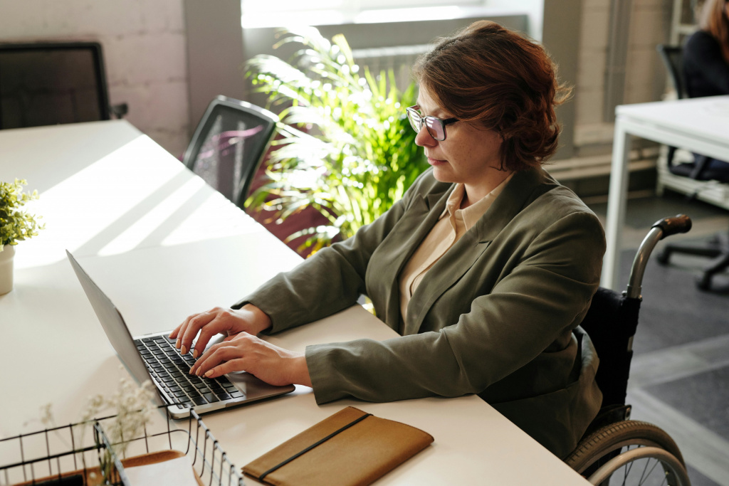 Female teacher in a wheelchair using a laptop